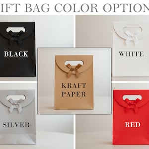 Pode incluir: Uma variedade de sacolas para presentes em v&aacute;rias cores: preto, branco, papel kraft, prata e vermelho. Cada sacola apresenta uma al&ccedil;a, um la&ccedil;o decorativo e o nome da cor impresso em branco.