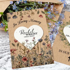 Könnte beinhalten: Eine Beileidskarte mit floralem Design und dem Text "In Loving Memory" sowie einem Namen und Daten. Die Karte hat einen herzförmigen Ausschnitt. Der Hintergrund ist eine Mischung aus Wildblumen in gedämpften Farben.