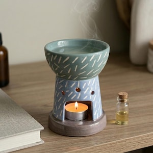 Può includere: Una tazza di ceramica bianca con un manico nero e la scritta "But First, Coffee" in grassetto nero. La tazza è appoggiata su una superficie di legno. La tazza è alta circa 10 cm.