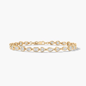 May include: A gold chain bracelet featuring a series of bezel-set diamonds in various shapes, including round, pear, marquise, and emerald cuts, linked together in a continuous design with a secure clasp mechanism visible at the center.