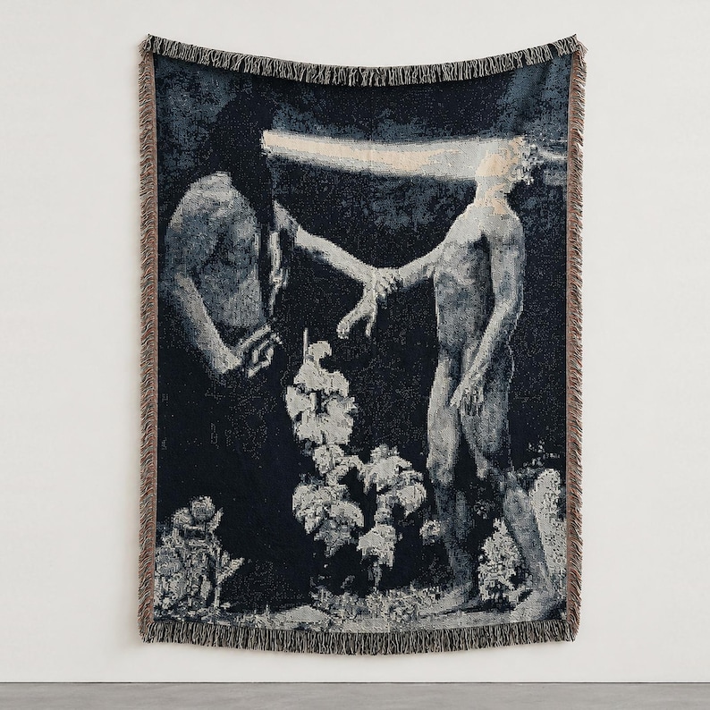 May include: A woven throw blanket featuring a dark, monochromatic scene of two figures standing in a landscape. One figure is shrouded in black, emitting a horizontal beam of light toward the other figure, who stands with an outstretched hand.