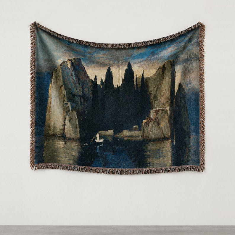 Puede incluir: Una manta tejida que presenta una reproducci&oacute;n del cuadro La isla de los muertos de Arnold B&ouml;cklin. La imagen muestra oscuras y elevadas formaciones rocosas que surgen de aguas azul profundo bajo un cielo sombr&iacute;o, con un peque&ntilde;o bote.