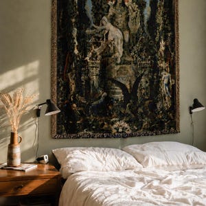 Puede incluir: Un tapiz de pared tejido rectangular que presenta una escena oscura y compleja con una figura central sentada en un trono, rodeada de follaje exuberante, elementos arquitect&oacute;nicos y un gran p&aacute;jaro negro, con un borde decorativo de flecos.