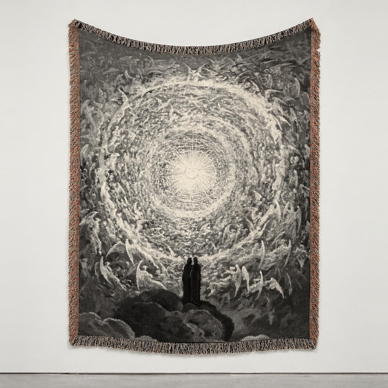 May include: A woven tapestry blanket featuring a monochromatic black and white illustration of two figures standing before a vast, swirling celestial vortex filled with winged beings, finished with a fringed edge and brown border.