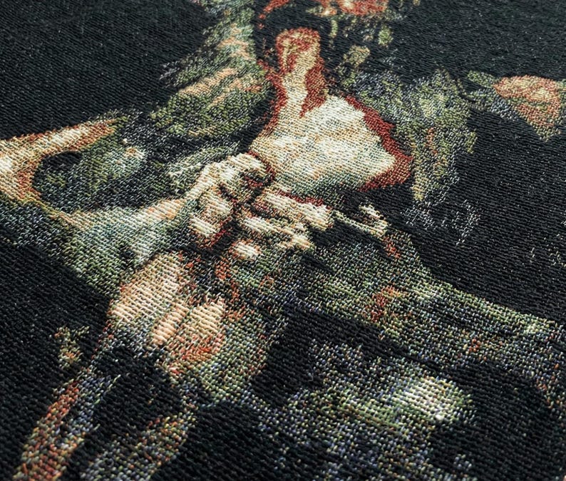 Pu&ograve; includere: Un tessuto intrecciato con uno sfondo nero profondo e un motivo complesso e multicolore composto da fili color verde spento, crema e marrone rossiccio. Il design mostra una trama strutturata simile a un arazzo con fibre intrecciate visibili.