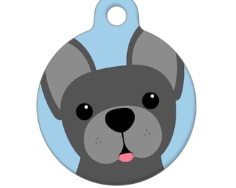 Puede incluir: Una etiqueta redonda para perro de color azul y gris con una imagen de dibujos animados de un bulldog francés gris con la lengua rosa fuera.