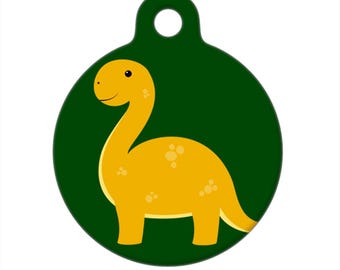 Può includere: Un'etichetta rotonda verde per animali domestici con un dinosauro giallo dei cartoni animati. Il dinosauro ha un collo lungo e una piccola testa con un sorriso.