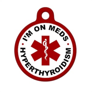 May include: Red round pet ID tag with a white background and black text that reads "I'm on meds. Hyperthyroidism". A red star of life symbol with a snake and staff is in the center.