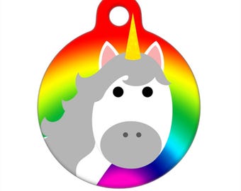 May include: A round rainbow-colored pet tag with a white unicorn face in the center. The unicorn has a gold horn and gray mane.