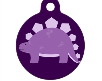 Può includere: Dinosauro viola con una schiena spinosa su uno sfondo viola scuro. Questo è un cartellino rotondo per animali domestici.
