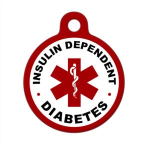 Puede incluir: Etiqueta redonda roja con fondo blanco y texto negro que dice "Insulin Dependent Diabetes". Un símbolo de estrella de la vida roja con una serpiente y un bastón negros está en el centro.