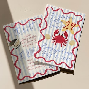 May include: Two invitation cards with a nautical theme. One card says "To Eat" with a list of food items. The other card says "The summer Caitlin turned 29" with a crab and starfish illustration. The cards have a blue and white striped background.