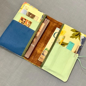 Travel Entertainment Organizer for adults or children, holds a 6x8 sketchbook, paperback book, drawing utensils, and more