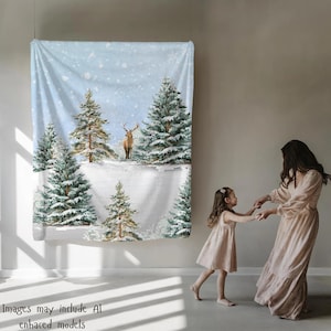 Könnte beinhalten: Ein Wandteppich mit Wintermotiv, der eine verschneite Landschaft mit Tannen und einem Hirsch zeigt. Der Wandteppich hat einen hellblauen Hintergrund mit fallenden Schneeflocken. Der Text "Images may include AI enhanced models" ist enthalten.