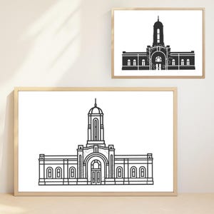 May include: Two framed prints featuring architectural line drawings. The larger print displays a detailed black and white illustration of a building with a central tower and arched entrance. The smaller print shows a similar design. Both are in light wood frames.