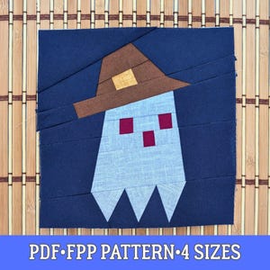 Op de afbeelding: Een stoffen blok met een spookontwerp, met een bruine hoed en drie rode vierkante ogen. De geest is lichtblauw, tegen een donkerblauwe achtergrond. De tekst "PDF FPP PATTERN 4 SIZES" staat onderaan.