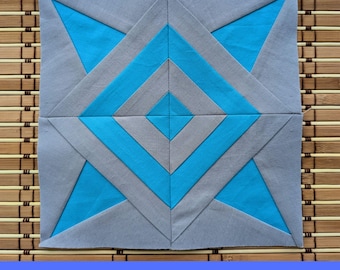 Könnte beinhalten: Ein quadratischer Quiltblock mit einem geometrischen Design in Grau- und Türkisblautönen. Der Block hat eine zentrale Raute und eckige Linien. Der Text unten lautet "PDF FPP PATTERN 7 SIZES".