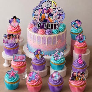 May include: A round cake with pink and blue ombre frosting, white drip, and a holographic topper featuring the text "WE'RE GOING UP" and "ALLIE" with character illustrations. Surrounding cupcakes feature toppers with K-pop themes, musical notes, disco balls, and character portraits.