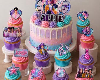 May include: A multi-tiered cake and cupcakes with a K-Pop theme. The cake is decorated with a holographic topper and the name "ALLIE". Cupcakes feature various K-Pop themed toppers, including hearts, stars, and musical notes. The frosting is pink, purple, and blue.