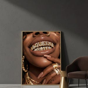 Può includere: Stampa incorniciata con primo piano di una bocca con denti d'oro e diamanti che compongono la scritta "QUEEN SHIT". La persona indossa gioielli d'oro, tra cui anelli, un piercing al naso e orecchini.