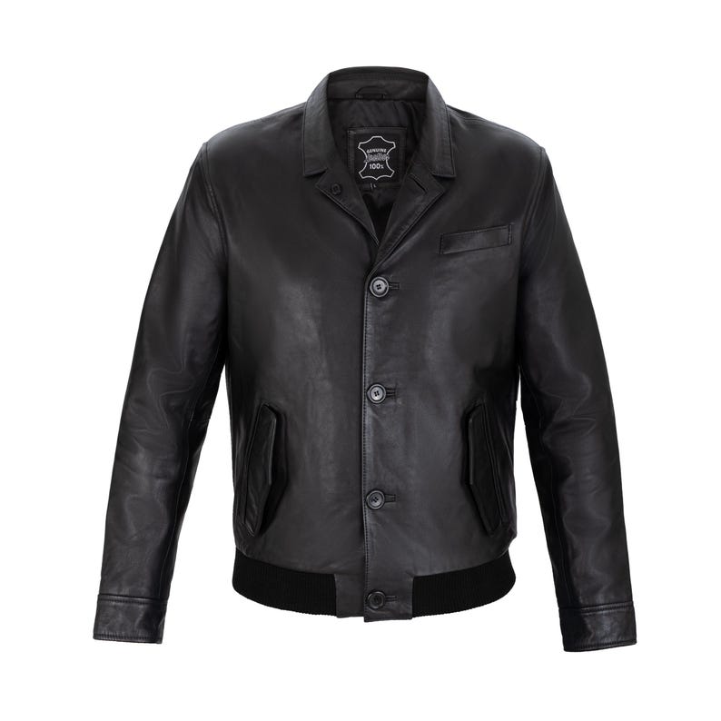 May include: A black leather jacket featuring a classic collar, a front button closure with four visible buttons, two side pockets, and a ribbed black hem. The interior label reads Genuine Leather 100%. The sleeves have simple cuffs and a smooth finish.