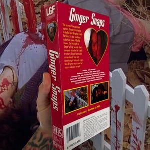 Puede incluir: Una cinta VHS roja de la pel&iacute;cula "Ginger Snaps" se muestra. La cinta presenta el t&iacute;tulo de la pel&iacute;cula en blanco, una imagen en forma de coraz&oacute;n y el logotipo de Lionsgate. La cinta est&aacute; etiquetada como "VHS Hi-Fi".