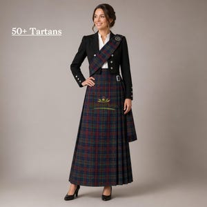 May include: A woman wearing a traditional Scottish outfit. The ensemble includes a long tartan skirt in shades of blue, green, and red, a black jacket, and a matching sash. The text "50+ Tartans" is visible in the upper left corner.