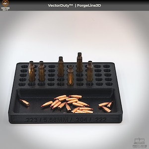 May include: A black 3D-printed ammunition tray with a grid of holes holding brass casings. The tray also contains several bullets and the text "223 / 5.56MM / .204 / .222". The Vector Duty and ForgeLine3D logos are visible.