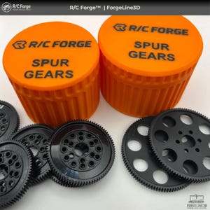 Puede incluir: Imagen de contenedores naranjas con la inscripción "R/C FORGE SPUR GEARS" y varios engranajes rectos negros. Los engranajes tienen diferentes patrones de agujeros y diseños de dientes. Los contenedores muestran el logotipo de R/C Forge.