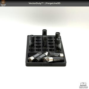 May include: A black 12-gauge shotgun shell holder with multiple cylindrical slots. The holder contains several black shotgun shells with silver bases. The text "12 GAUGE" is printed on the front of the holder.