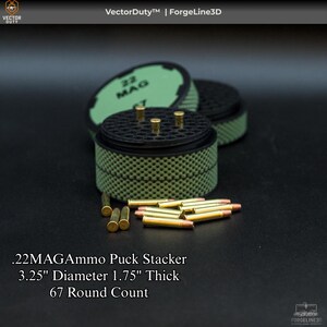 May include: A black and green .22MAGAmmo Puck Stacker with a diameter of 3.25 inches and a thickness of 1.75 inches. The stacker holds 67 rounds and is accompanied by loose ammunition. The text on the stacker reads "22 MAG".