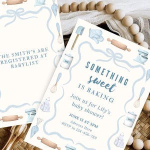 Könnte beinhalten: Zwei Babyparty-Einladungen mit Backthema. Die cremefarbenen Einladungen zeigen blaue Aquarellillustrationen von Backutensilien und den Text "Something Sweet is Baking". Die Einladungen enthalten Datum, Uhrzeit und RSVP-Informationen.