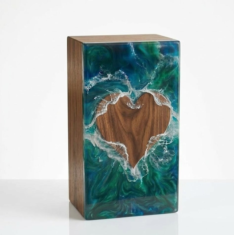 May include: A rectangular wooden box with a heart-shaped cutout. The heart is made of wood, surrounded by a swirling design of blue, green, and white resin. The box has a natural wood grain finish.