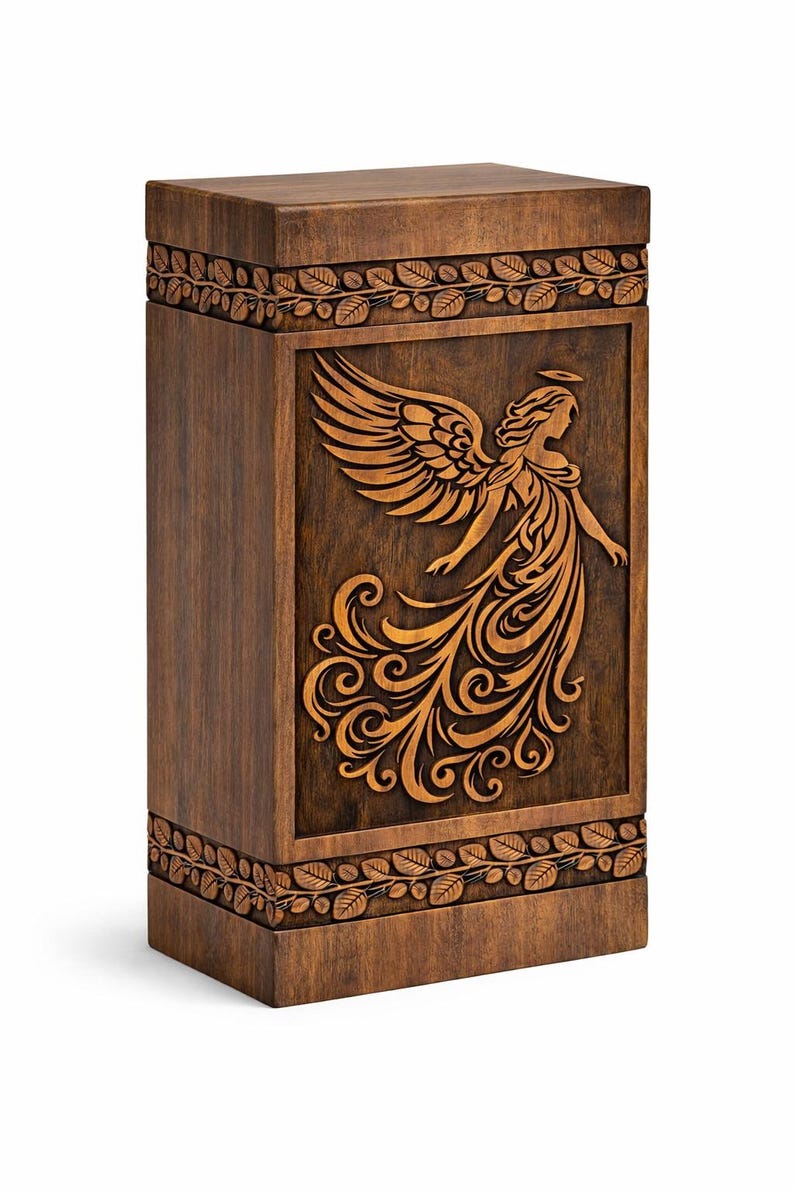 Op de afbeelding: Houten urn met een gebeeldhouwd engelontwerp. De donkerbruine urn heeft een rechthoekige vorm met een gedetailleerd reli&euml;f van een engel met vloeiend haar en vleugels. De boven- en onderranden hebben een bladerpatroon.