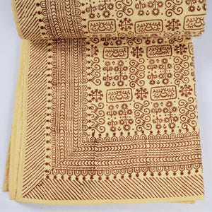 May include: A quilted textile featuring a cream-colored base with a repeating dark brown block-printed pattern. The design includes geometric borders, diagonal stripes, and rectangular panels filled with intricate floral and scroll motifs.
