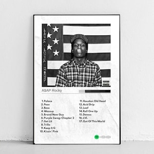 May include: A framed black and white poster featuring A$AP Rocky. The image includes a portrait of the artist in front of an American flag, with a tracklist below. The Spotify logo is at the bottom.