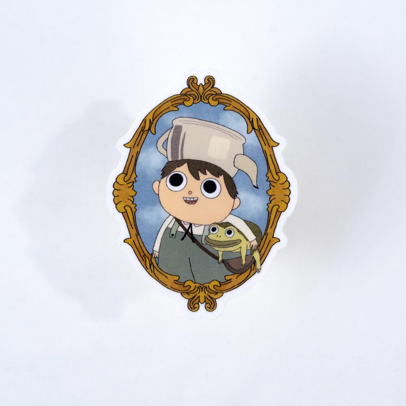 May include: A sticker featuring a cartoon illustration of a boy wearing a pot on his head and overalls, with a frog in a bag. The image is framed in a gold ornate oval, set against a blue sky background.