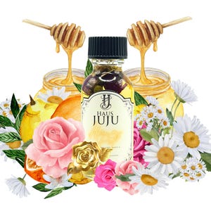 Könnte beinhalten: Eine Flasche Haus Juju Honey Pot Öl mit schwarzem Verschluss, umgeben von rosa und goldenen Rosen, Gänseblümchen und Zitrusfrüchten. Zwei Honiglöffel tropfen Honig in Gläser. Das Etikett lautet "Haus Juju Honey Pot".