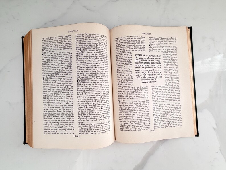 Puede incluir: Un libro abierto con el t&iacute;tulo "BEHAVIOR" en la parte superior de cada p&aacute;gina. Las p&aacute;ginas est&aacute;n llenas de texto peque&ntilde;o y negro. El libro tiene una encuadernaci&oacute;n negra y est&aacute; sobre una superficie blanca.