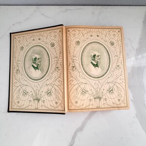 Puede incluir: Dos libros antiguos abiertos revelan ilustraciones detalladas. Las cubiertas y p&aacute;ginas est&aacute;n envejecidas con un color crema. Cada cubierta presenta un retrato dentro de un marco ovalado decorativo, rodeado de intrincados patrones florales y geom&eacute;tricos verdes.