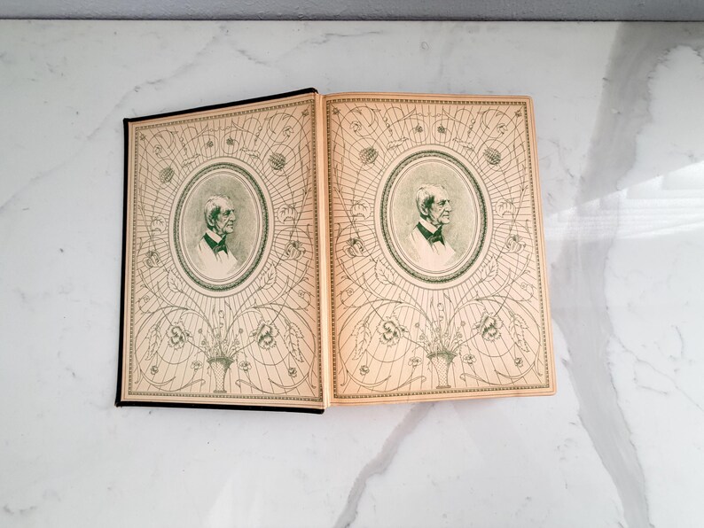 Puede incluir: Dos libros antiguos abiertos revelan ilustraciones detalladas. Las cubiertas y p&aacute;ginas est&aacute;n envejecidas con un color crema. Cada cubierta presenta un retrato dentro de un marco ovalado decorativo, rodeado de intrincados patrones florales y geom&eacute;tricos verdes.