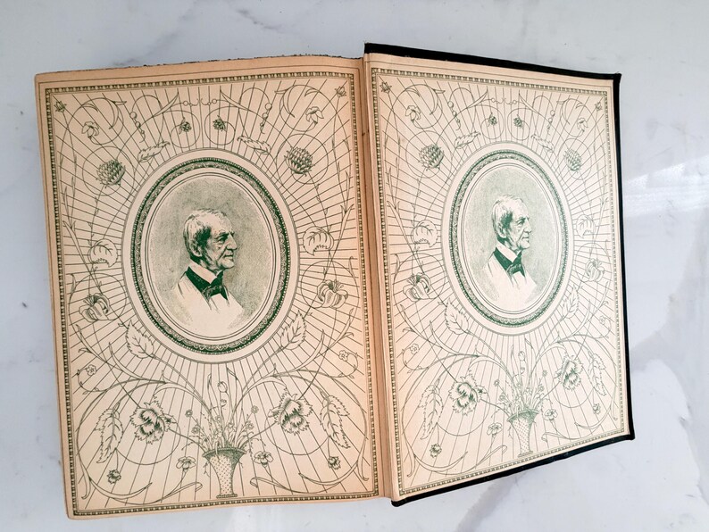 Puede incluir: Libro abierto con dos p&aacute;ginas enfrentadas. Cada p&aacute;gina presenta un retrato de un hombre en un marco ovalado, rodeado de un intrincado dise&ntilde;o floral y geom&eacute;trico verde sobre un fondo crema. El libro tiene un lomo negro.