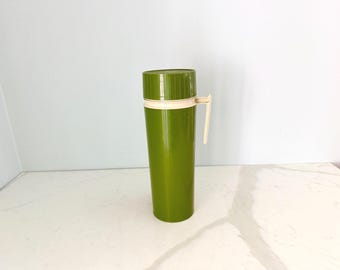 Termo vintage modelo 7402 de los años 70, color verde aguacate, botella alta con asa y tapa de rosca. Vaso térmico retro de mediados de siglo.