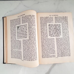 Puede incluir: Un libro abierto con encuadernaci&oacute;n negra, con texto en p&aacute;ginas crema envejecidas. El t&iacute;tulo "MAN THE REFORMER" es visible en la parte superior de las p&aacute;ginas. El texto est&aacute; en una fuente serif, y el libro est&aacute; abierto sobre una superficie blanca.