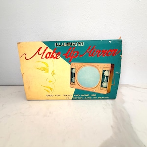 May include: A rectangular cardboard box for an illuminated make-up mirror. The box features a teal and cream color scheme with a graphic of a face and the mirror. Text reads: ILLUMINATED Make-Up Mirror GOOD FOR TRAVEL AND HOME USE FOR BETTER CARE OF BEAUTY.