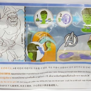 Puede incluir: Un paquete con una figura de juguete de Hulk. El embalaje incluye ilustraciones de Hulk, instrucciones y el logotipo de Marvel. El juguete es verde y tiene una base verde. El paquete tambi&eacute;n incluye el texto "FS541".