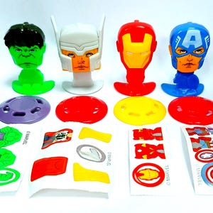 Puede incluir: Colecci&oacute;n de juguetes de personajes de superh&eacute;roes de Marvel, incluyendo Hulk, Thor, Iron Man y Capit&aacute;n Am&eacute;rica. Cada figura tiene un esquema de color y dise&ntilde;o &uacute;nicos, con bases y hojas de pegatinas a juego.