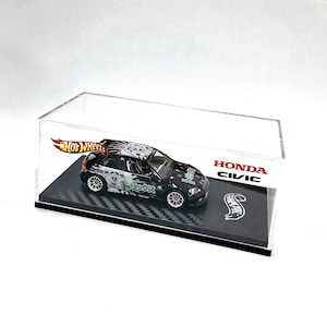 May include: A black Hot Wheels Honda Civic diecast model car in a clear display case. The car has detailed graphics and Japanese text. The display case has the Hot Wheels logo and the Honda Civic name.