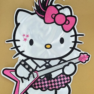 May include: White cartoon cat patch with a pink bow, mohawk, and star-shaped accents. The cat is wearing a black and white striped shirt and a pink and black checkered skirt. It is holding a pink star-shaped guitar.