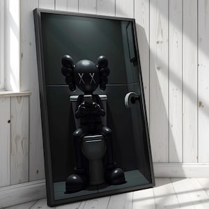 May include: A framed artwork depicting a black sculpture of a cartoon figure on a toilet, focused on a phone. The figure has large, rounded ears and crossed-out eyes. The artwork is set against a dark grey background.